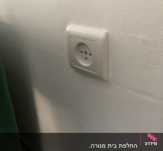 שקע חשמלי בקיר לבן